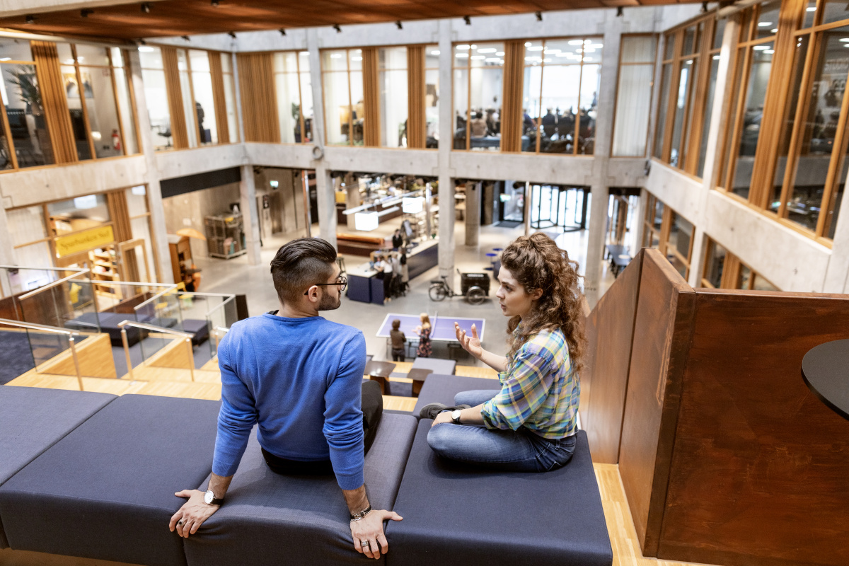 Two people sitting in a modern office environment discussing