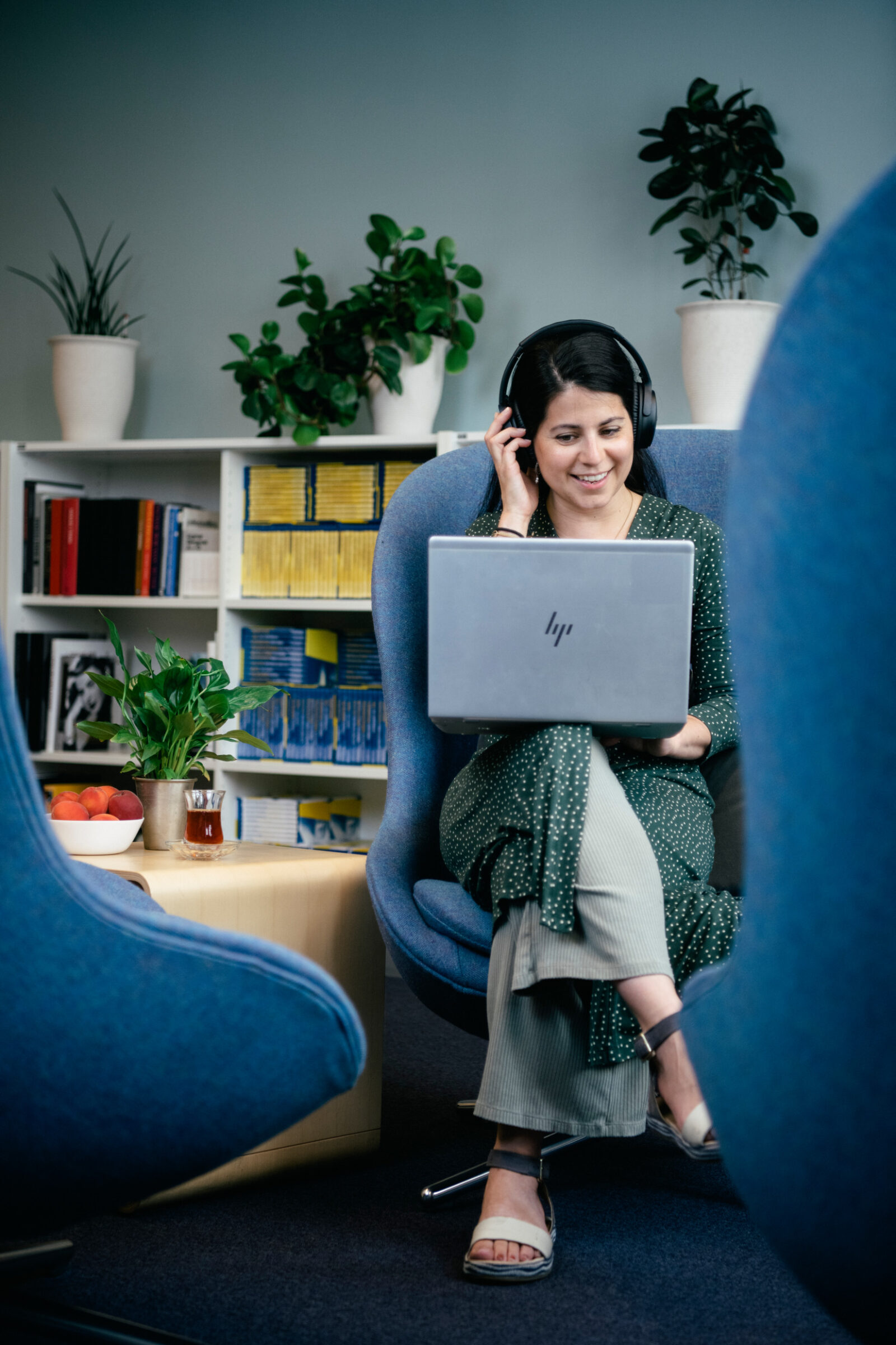 Woman sitting in a armchair working with a laptop