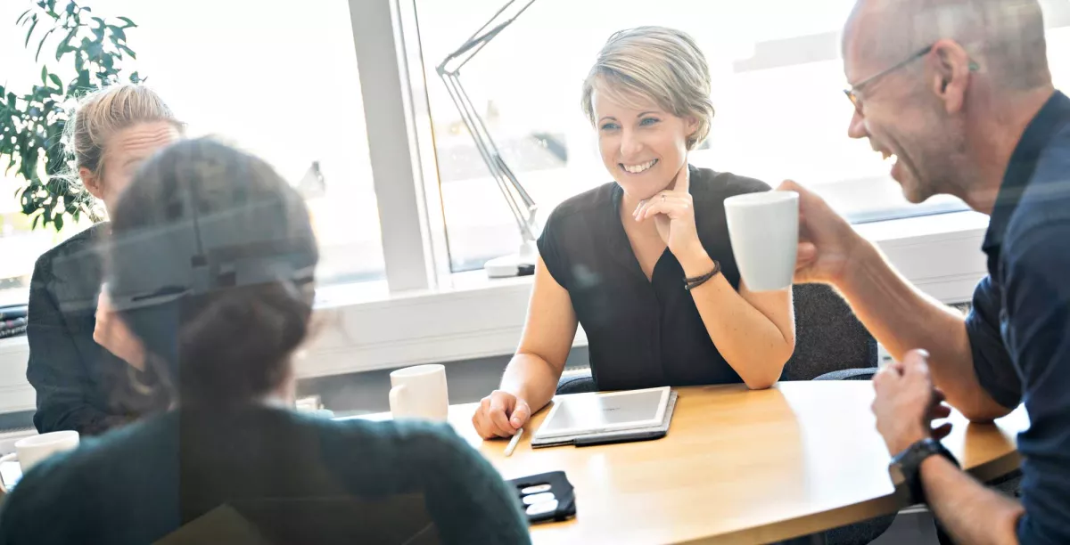 Colleagues sitting around a table and laughing